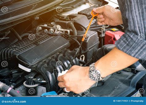 Man Or Auto Mechanic Worker Hands Checking The Car Engine Oil And