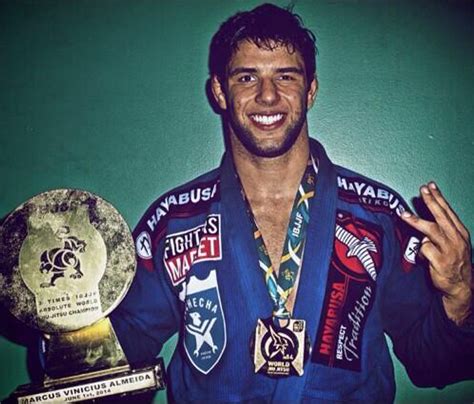 A Man Holding Two Trophies In His Hands