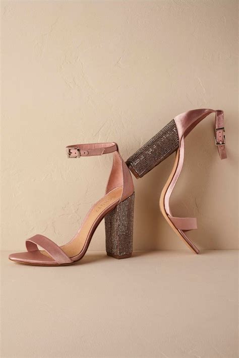 A Pair Of Pink High Heeled Shoes Sitting On Top Of A White Table Next