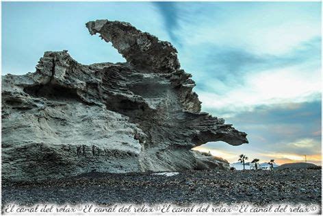 A Rock Formation On The Beach At Sunset