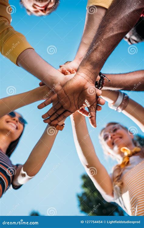 Bottom View Of Multiracial Young Friends Holding Hands Together With