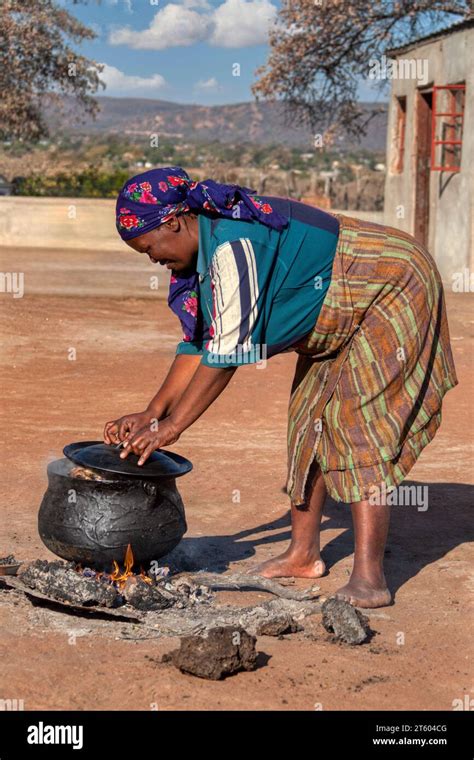 African Woman Cooking Boiling Outdoors Some Meat Setswa On A Three