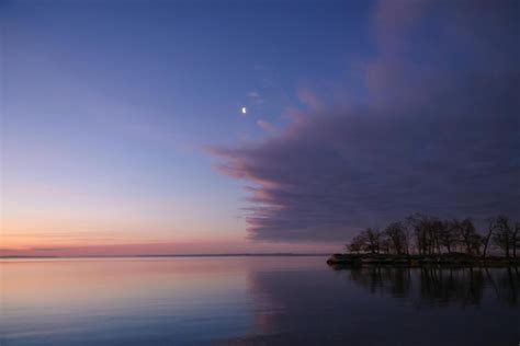 Premium Photo A Sunset Is Reflected On The Water And The Sky Is Pink