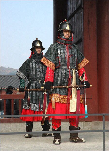 Two Men Dressed In Black And Red Standing Next To Each Other