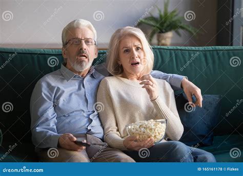 Mature Couple Sitting On Couch Watching Drama Movie Stock Photo Image
