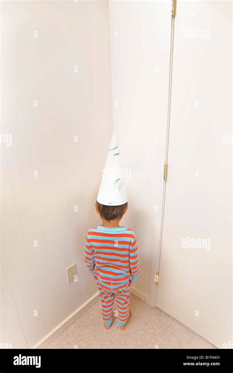 Boy Wearing Dunce Cap In Corner Stock Photo Alamy