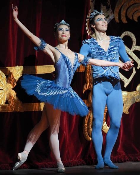 Two Ballerinas In Blue Tutus And Leotards On Stage With Red Curtains