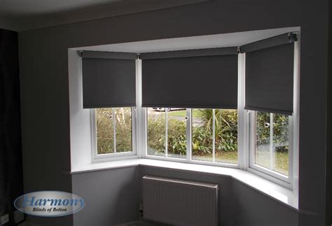 Grey Senses Roller Blinds With Chrome Finishes In A Bay Window