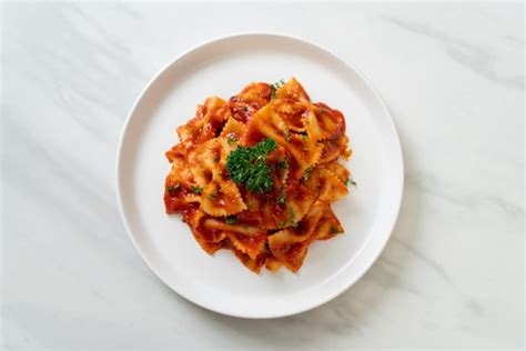 Premium Photo | Farfalle pasta in tomato sauce with parsley