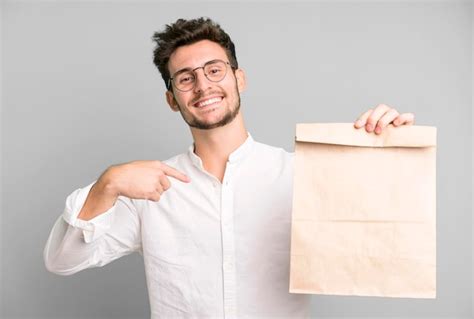 Joven Empleado Guapo Con Una Bolsa De Papel Para Llevar Comida Foto