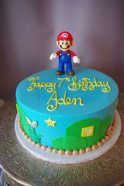 a blue birthday cake with a mario figure on top