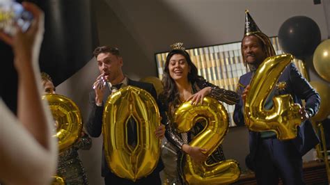 A Cheerful Group Of Friends Holding A 2024 Balloon Sign Takes A Photo