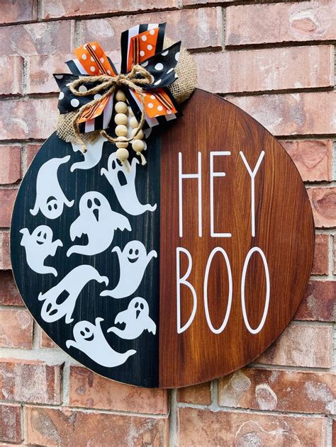 A Wooden Sign That Says Hey Boo On It And Has Halloween Decorations