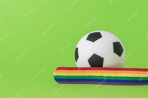 Premium Photo A Ribbon In Lgbt Colors And A Soccer Ball On A Green Background The Concept Of