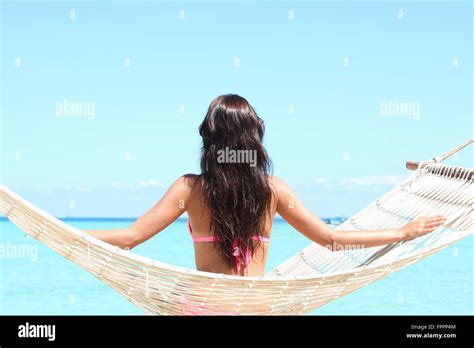 Vue arrière d une woman in bikini assis sur un hamac sur une plage au bord de la mer Photo Stock