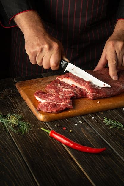 El Chef Corta La Carne De Vacuno Fresca Cruda En Una Tabla De Cortar