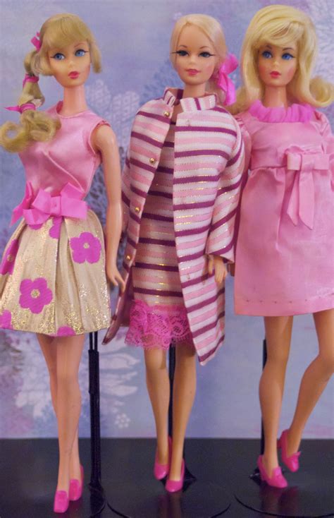 Three Barbie Dolls Standing Next To Each Other