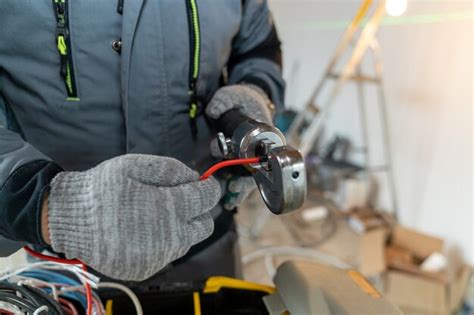 El Electricista Se Pone Guantes Y Procesa Los Bordes De Los Cables Con