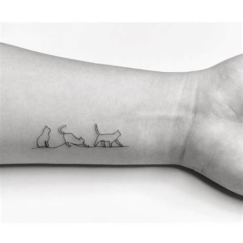 One line style cats tattooed on the wrist.