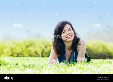 Young happy smiling girl lying on grass Stock Photo - Alamy