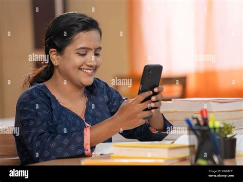 Side View Of Indian Teenager Girl Busy Using Mobile Phone While