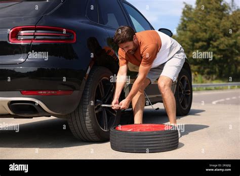 Man Changing Wheel Of Car On Roadside Outdoors Stock Photo Alamy