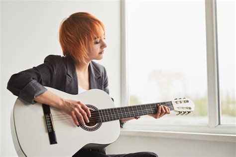 Premium Photo | Talented young female guitarist performing song during ...