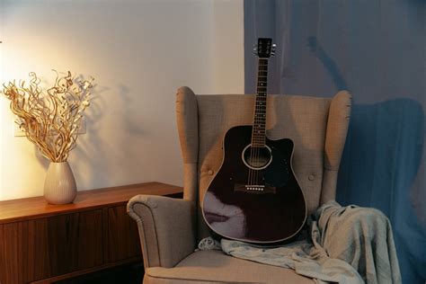 Brown Acoustic Guitar On Brown Sofa Chair · Free Stock Photo