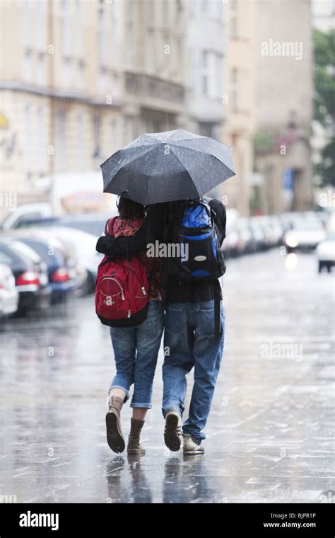 Couple with umbrella in the rain Stock Photo - Alamy