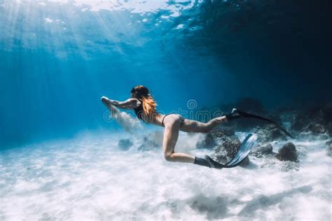 Woman Freediver Posing Over Sandy Bottom With Fins Freediving In Blue