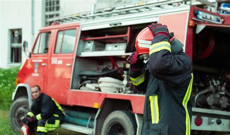 Premium Photo Firefighter With Uniform And Helmet Stand In Front Of
