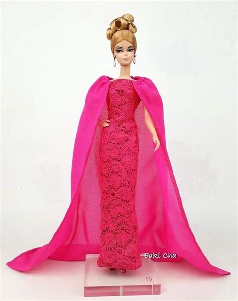 A Barbie Doll Wearing A Pink Dress And Cape