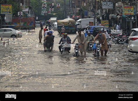 Lahore Pakistan 31st July 2021 Pakistani Commuters Wade Through A Flooded Street After Heavy