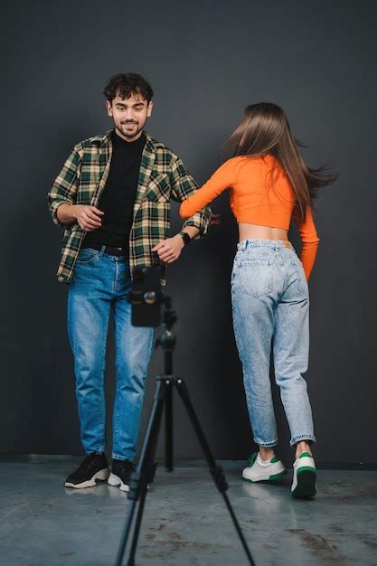 Pareja milenaria grabando video divirtiéndose bailando mientras filma