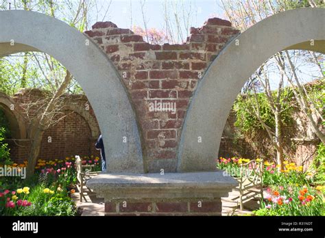 A Broken Brick And Stone Archway Enshrouded By Vines And Foliage Stock
