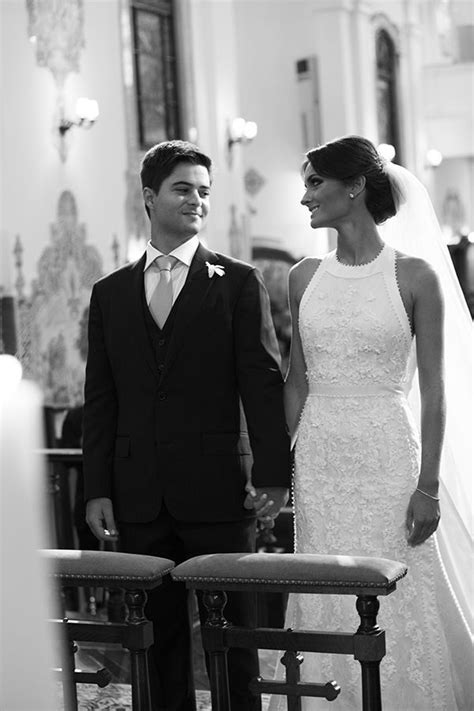 A Bride And Groom Standing Next To Each Other In Front Of The Alter At