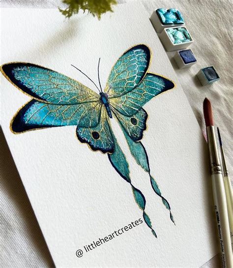 A Painting Of A Blue Butterfly On Paper Next To Some Watercolors And