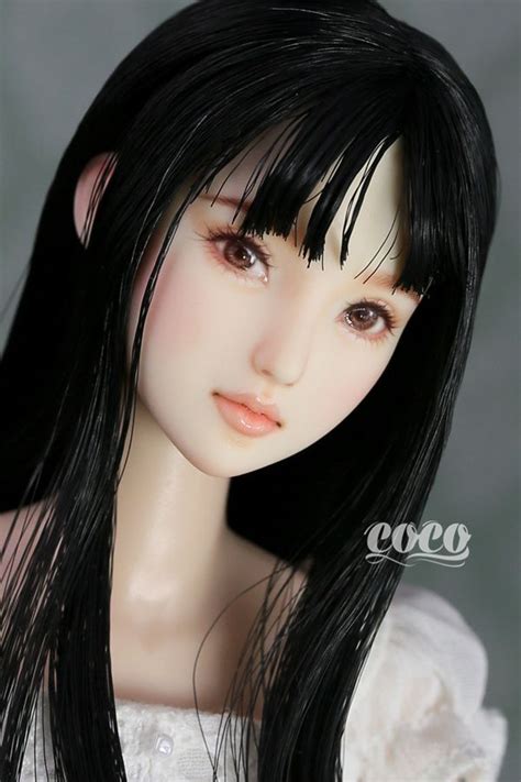 A Doll With Long Black Hair Wearing A White Dress