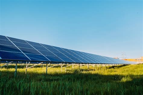 Fazenda de painéis solares fotovoltaicos dia ensolarado conceito de