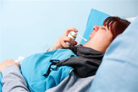 Image Of Sick Man Using Nasal Spray While Lying In Bed Stock Image