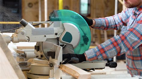 Builder saws a board with a circular saw in the cutting a wooden plank ...