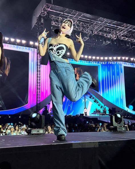 A Woman In Overalls On Stage With Her Legs Spread Out And One Leg Up