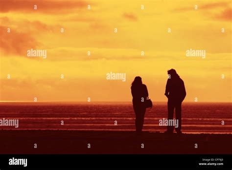 A young couple, silhouette by the ocean at sunset Stock Photo - Alamy