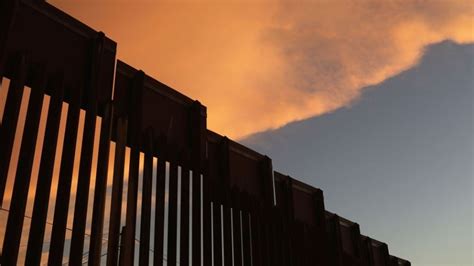 Border agency shares video of migrants scaling wall with ladder