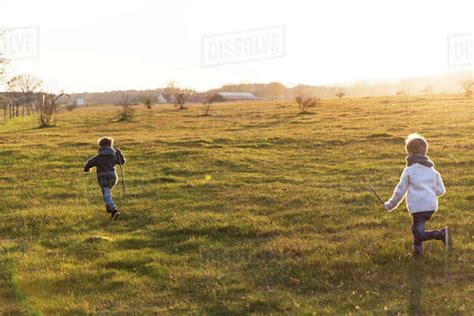 Boys Running Through Meadow Stock Photo Dissolve