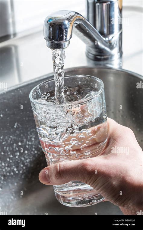 Water Runs Into A Glass From A Tap In A Kitchen Stock Photo Alamy