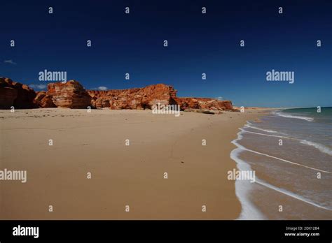 Rock Formations On Beach Against Clear Blue Sky Stock Photo Alamy