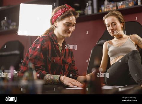Woman Tattoo Artist Smiling While Working With Client Stock Photo Alamy