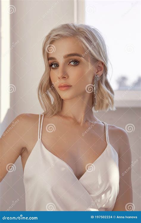 Portrait Of A Blonde Woman In A Beautiful White Dress In The Evening