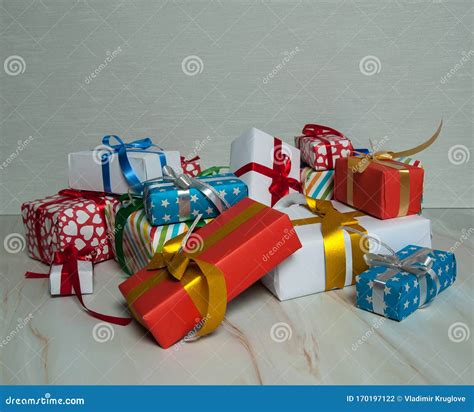 Many Multi Colored Gift Boxes With Ribbons And Bows Lie On A Marble